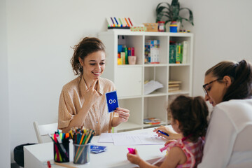 psychologist talks to young girl at child daycare