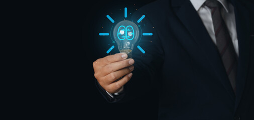 Businessman holding glowing light bulb with symbol brain and creative thinking ideas.