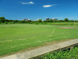 Obraz premium 江戸川河川敷の除草された跡の残る真夏の野球場風景