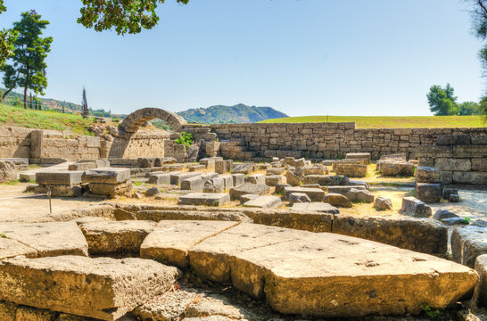 Ruins of the ancient site of Olympia, in Greece where the Olympic games originate from. View of the archaeological site with Ionic pillars on a summer day.
