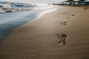 footprints on the beach at sunset