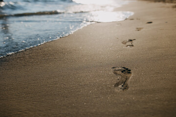 footprints on the beach at sunset