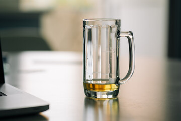 a beer mug with an unfinished beer on the table
