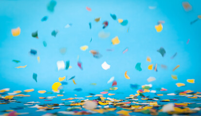 Fototapeta na wymiar Colorful confetti in front of blue background