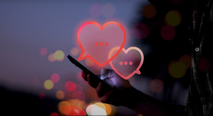 illustrated red speech bubbles shaped as a heart above a hand holding a smartphone with screen...