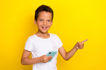 Photo of pretty boy blogger telephone user hand arm demonstrate offer modern devise shop empty space isolated on yellow color background