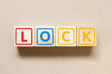 Color letter block in word lock on wood background