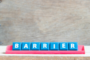 Tile alphabet letter with word barrier in red color rack on wood background