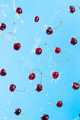 Ripe cherry flies in splashes of water