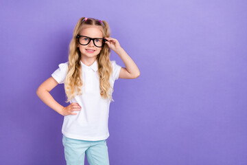 Photo of little pupil girl ponytails hand touch spectacles empty space banner wear trendy white outfit isolated on purple color background