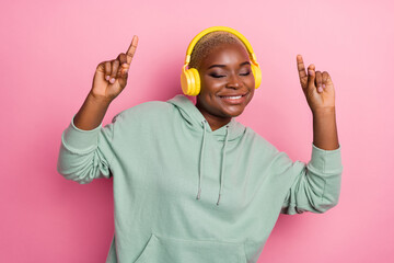 Photo of good mood lovely female have fun dancing listening favorite song in headphones isolated on pink color background