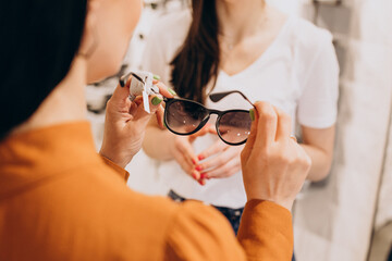 Female ophtalmologist demonstrating spectacles in optician shop