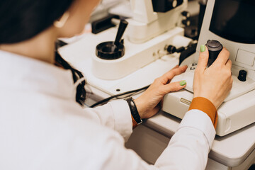 Fototapeta premium Female optician working at ophthalmology center