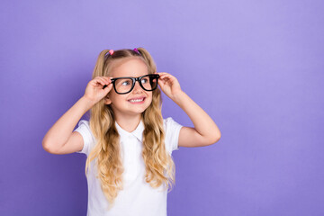 Photo of nice little schoolgirl ponytails hands touch specs empty space poster wear trendy white outfit isolated on purple color background
