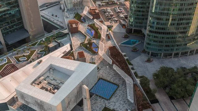 Dubai international financial center skyscrapers with promenade on a gate avenue aerial timelapse during all day. Futuristic mosque and walking area around with shadows moving fast