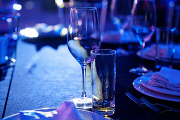 empty wine glasses and plates on the table in the restaurant hall. 