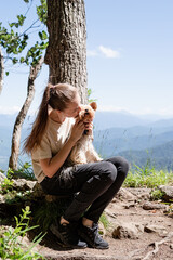 Obraz premium young woman holding small dog puppy yorkshire terrier hiking at the mountains