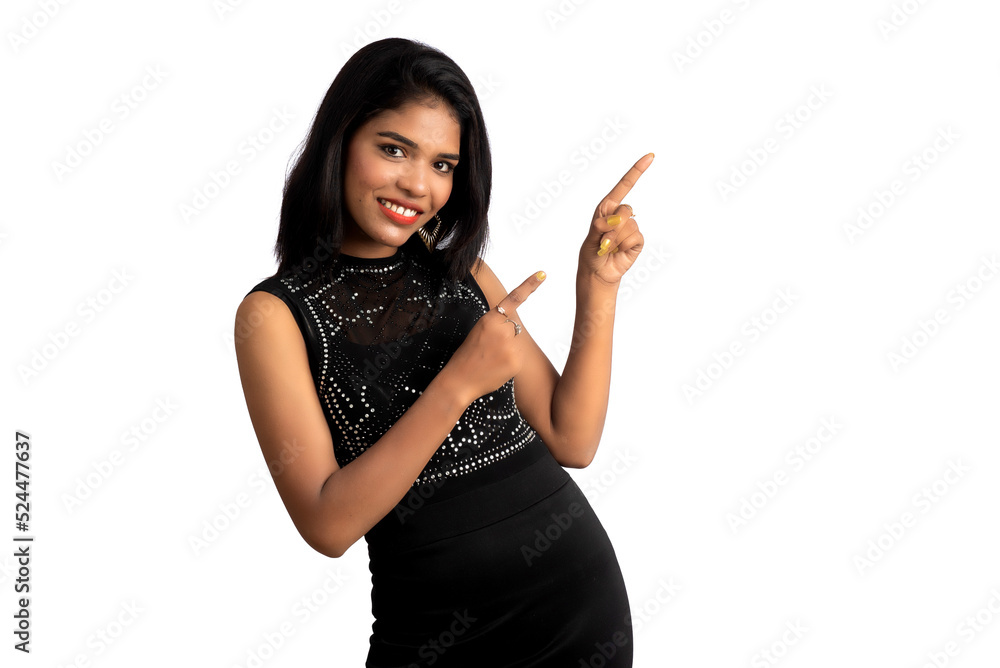 Sticker portrait of a successful cheerful young girl pointing and presenting something with hand or finger w