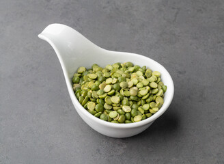 Raw dried green peas in a bowl over stone background