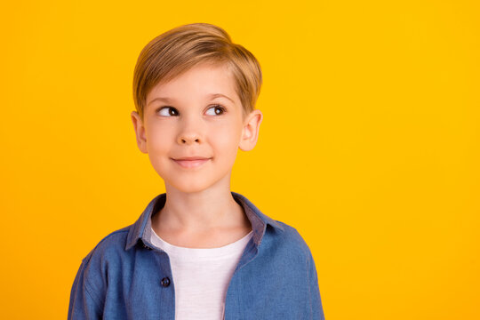 Photo of minded creative boy look interested empty space hmm deep isolated on yellow color background