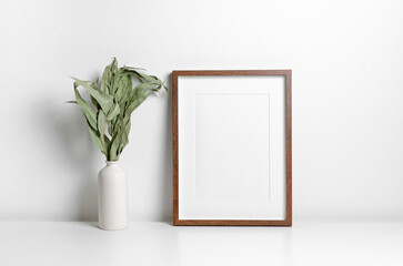 Portrait wooden frame mockup in white interior.