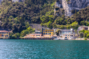 Fototapeta na wymiar A hotel is built into the rocky slope on the shore of Lake Garda in Italy