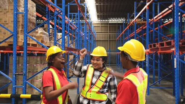Male and female warehouse workers join hands as teamwork when the job is done.