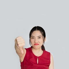 Upset beautiful Asian woman with a frowning  sad, grimacing disappointed, show thumbs-down , give...