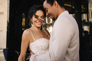 Stylish stunning couple together on their wedding day against the backdrop of a city hotel. Luxury...