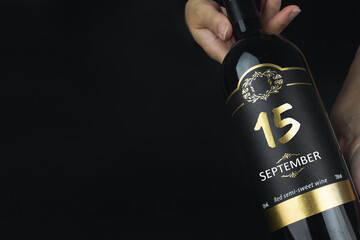 September 15th. Day 15 of month, Calendar date. Hands hold bottle of red wine with a calendar date...