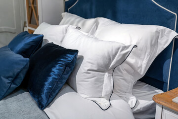 White pillow on blue bed decoration interior of bedroom. White pillows, duvet and duvet case on blue bed.