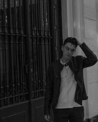 hombre con chaqueta de cuero peinándose en portal 