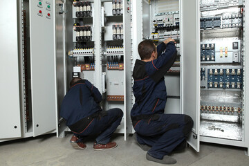 Electrician engineer work tester measuring voltage and current of power electric line in electical...