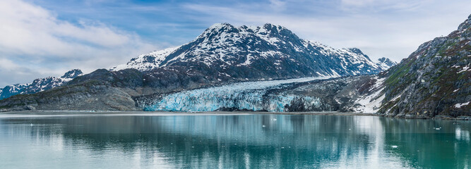 A panorama view across the waters of Glacier Bay towards the Reid Glacier, Alaska in summertime