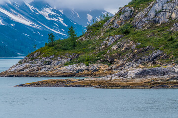 A view along the rocky shoreline of Glacier Bay, Alaska in summertime