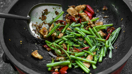 Stir-Fried Chinese Morning Glory with chicken in frying pan background.traditional food asian Thailand.Hot and spicy. Food for good health and diet.