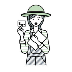 立って書類とカードを手に持つ農家の女性