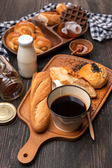 Delicious breakfast - Black coffee, bread, milk and honey on the wooden table.