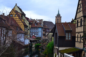 Colmar, France - December 27th 2021: View of the old streets during winter, at Christmas time. Focus on a small river going throught the city. 