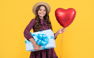 cheerful teen child with red heart balloon and present box on yellow background