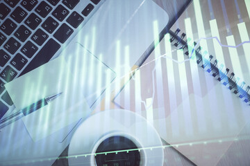 Stock market graph and top view computer on the table background. Double exposure. Concept of financial education.