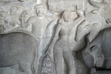 Human rock relief sculptures carved in the rock cut ancient cave temple in Mahabalipuram, Tamilnadu. Indian rock art of bas relief human sculptures at rock cut historical monolithic cave in Tamilnadu.