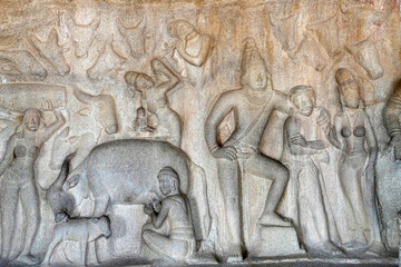 Human rock relief sculptures carved in the rock cut ancient cave temple in Mahabalipuram, Tamilnadu. Indian rock art of bas relief human sculptures at rock cut historical monolithic cave in Tamilnadu.