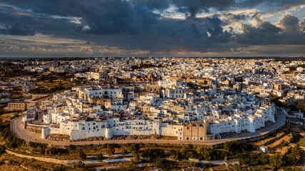 Overview of Ostuni (BR), the white city perched on the hill, with the typical white houses. Aerial photo with the drone of June 2022 photo taken at dawn. - obrazy, fototapety, plakaty