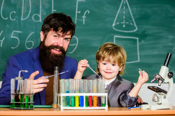 Empowered by Innovation. Little kid learning chemistry in school laboratory. Back to school. father and son at school. school kid scientist studying science. teacher man with little boy