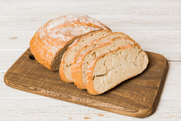 Assortment of freshly sliced baked bread with napkin on rustic table top view. Healthy unleavened bread. French bread slice