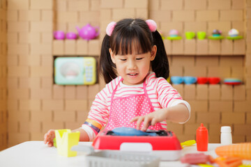 young girl pretend playing food preparing at home