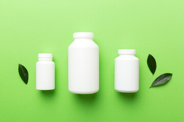 supplement pills with medicine bottle health care and medical top view. Vitamin tablets. Top view mockup bottle for pills and vitamins with green leaves, natural organic bio supplement, copy space