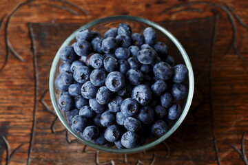 Blueberries in a bawl, fresh berry on the wooden table