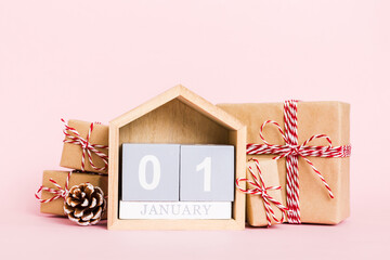 1 january. Christmas composition on colored background with a wooden calendar, with a gift box,...